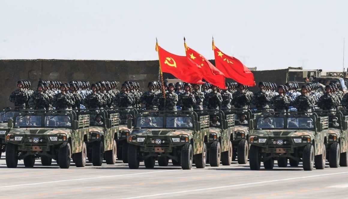 Chinese soldiers carry the flags of (L to R) the Communist Party, the state, and the People's Liberation Army during a military parade at the Zhurihe training base in China's northern Inner Mongolia region on July 30, 2017. China held a parade of its armed forces on July 30 to mark the 90th anniversary of the People's Liberation Army (PLA) in a display of military might. / AFP PHOTO / STR / China OUT (Photo credit should read STR/AFP via Getty Images)