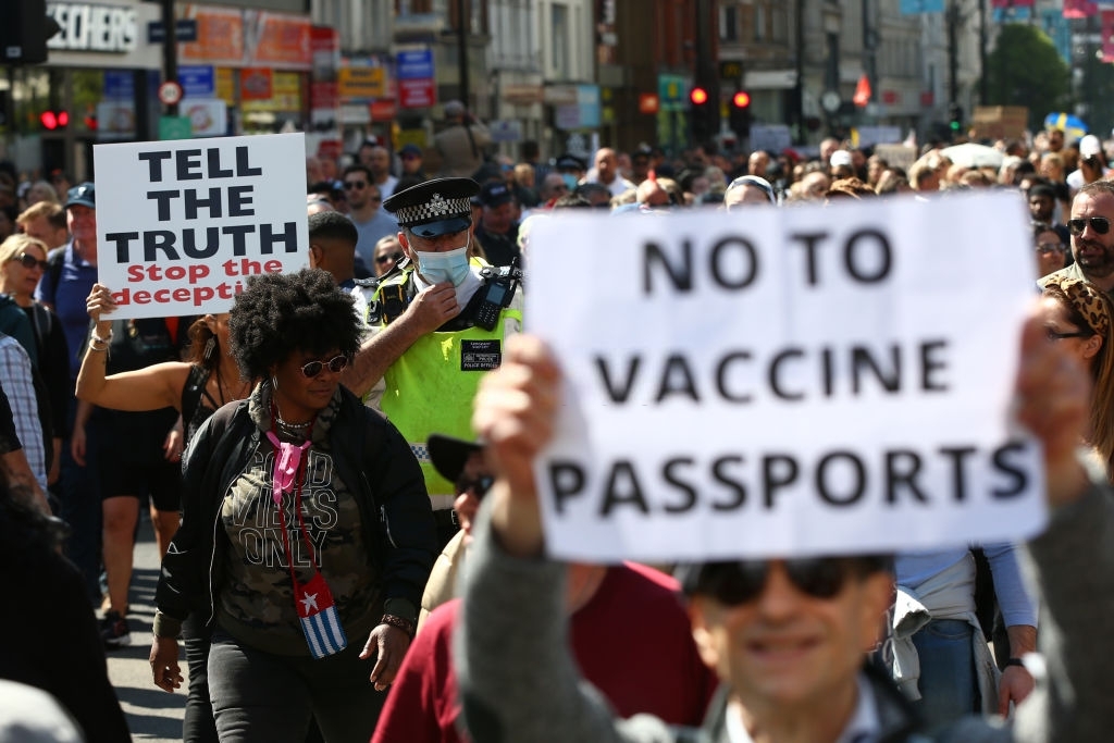 LONDON, ENGLAND - APRIL 24: A Met Police officer walks amongst protestors during a "Unite For Freedom" anti-lockdown demonstration held to protest against the use of vaccine passports in the United Kingdom, on April 24, 2021 in London, England. The proposed vaccine passports would enable members of the public to prove that they have received a COVID-19 vaccination, which many argue will allow major events to take place. Opposers of the scheme fear that the passports will result in discrimination against those who have not been vaccinated. (Photo by Hollie Adams/Getty Images)