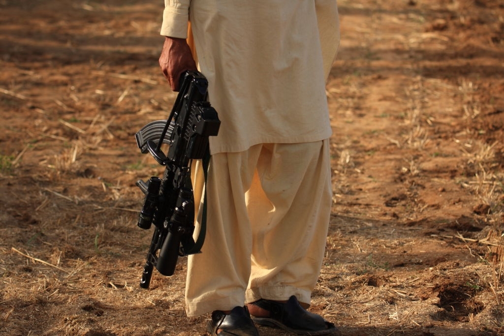 Seorang anggota Taliban memegang senjata