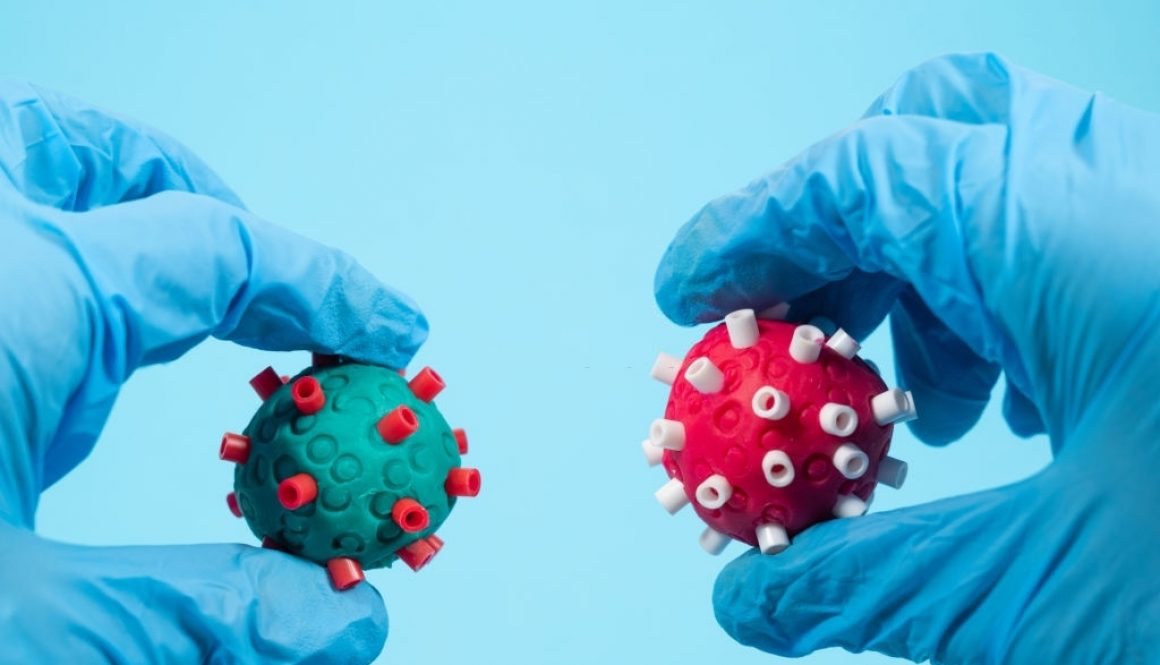 Para ilmuwan dengan sarung tangan bedah memegang dua virus corona berbeda dengan warna berbeda di tangan. (Gambar kreatif. - stok foto melalui Getty Image)