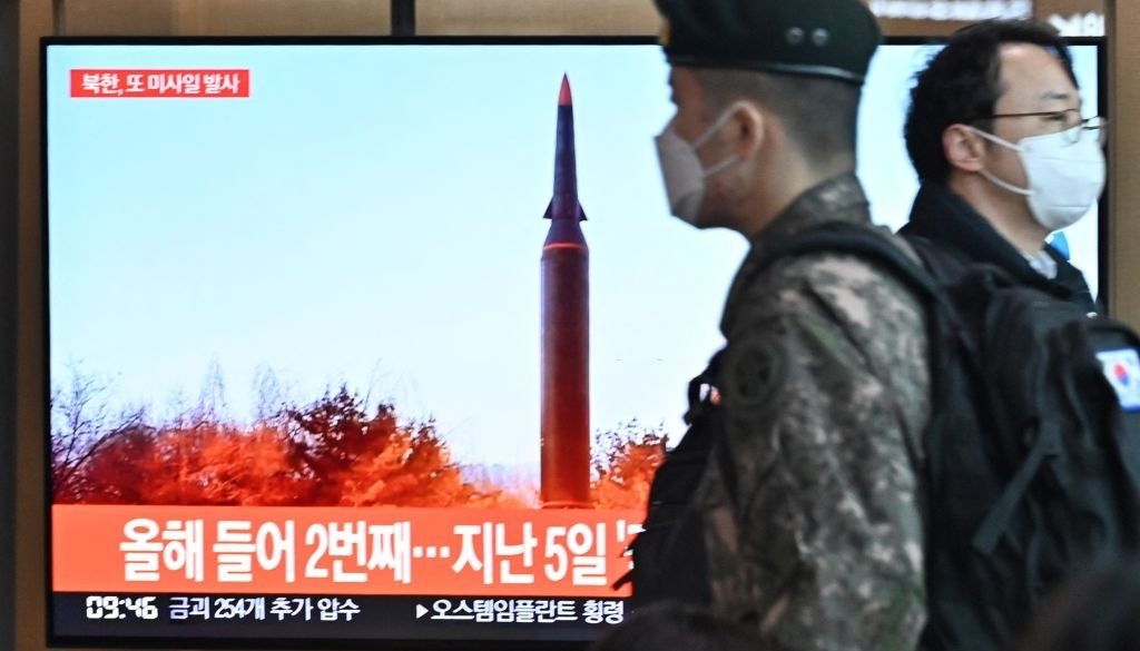 People walk past a television screen showing a news broadcast with file footage of a North Korean missile test, at a railway station in Seoul on January 11, 2022, after North Korea fired a "suspected ballistic missile" into the sea, South Korea's military said, less than a week after Pyongyang reported testing a hypersonic missile. (Photo by Anthony WALLACE / AFP) (Photo by ANTHONY WALLACE/AFP via Getty Images)