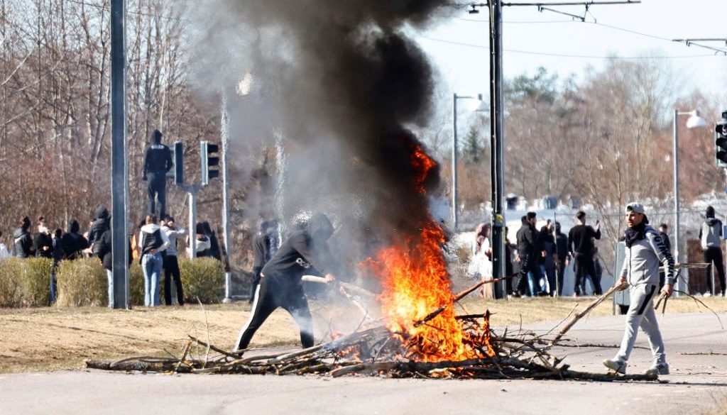 TOPSHOT - Protester build a burning barricade on a street during rioting in Norrkoping, Sweden on April 17, 2022. - Plans by a far-right group to publicly burn copies of the Koran sparked violent clashes with counter-demonstrators for the third day running in Sweden, police said on April 17, 2022. - Sweden OUT (Photo by Stefan JERREVANG / various sources / AFP) / Sweden OUT (Photo by STEFAN JERREVANG/TT News Agency/AFP via Getty Images)