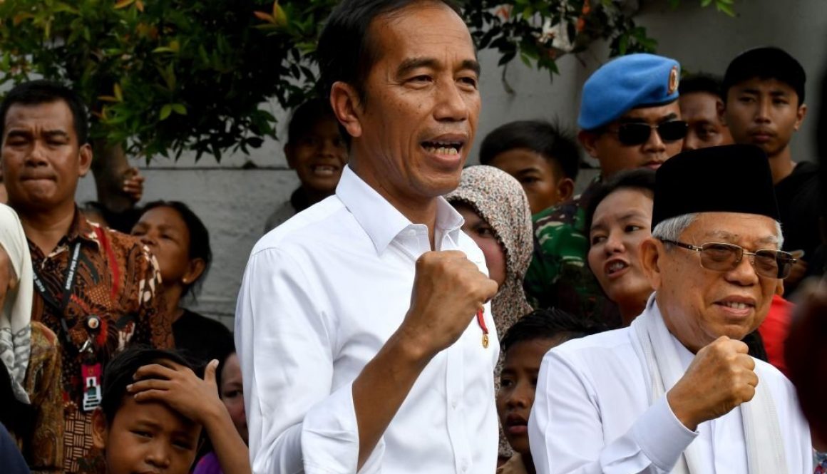 Indonesian President Joko Widodo (C) and his running mate Ma'ruf Amin (R) gesture while visiting a neighbourhood in Jakarta on May 21, 2019. - Thousands of soldiers fanned out across Jakarta on May 21 after the surprise early announcement of official results in Indonesia's election showed Joko Widodo re-elected leader of the world's third-biggest democracy. (Photo by GOH Chai Hin / AFP) (Photo credit should read GOH CHAI HIN/AFP via Getty Images)