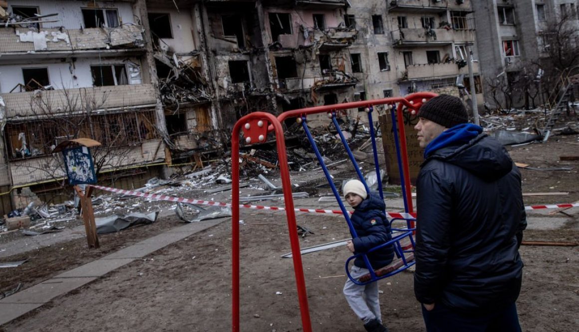 KYIV, UKRAINE - FEBRUARY 25: A boy plays on a swing in front of a damaged residential block hit by an early morning missile strike on February 25, 2022 in Kyiv, Ukraine. Yesterday, Russia began a large-scale attack on Ukraine, with Russian troops invading the country from the north, east and south, accompanied by air strikes and shelling. The Ukrainian president said that at least 137 Ukrainian soldiers were killed by the end of the first day. (Photo by Chris McGrath/Getty Images)