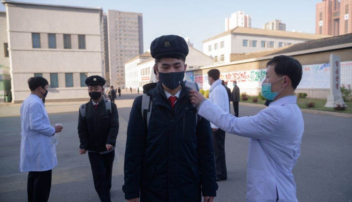 TOPSHOT - Students wearing face masks disinfect their hands and undergo a temperature check as they arrive for a lecture on preventative measures against the COVID-19 novel coronavirus at the Pyongyang University of Medicine in Pyongyang on April 22, 2020. - Pyongyang has imposed tight restrictions against the pandemic that has swept the world since emerging in neighbouring China, closing its borders and for a time quarantining thousands of its own citizens as well as hundreds of foreigners, and insists that it has not seen a single case. (Photo by KIM Won Jin / AFP) (Photo by KIM WON JIN/AFP via Getty Images)