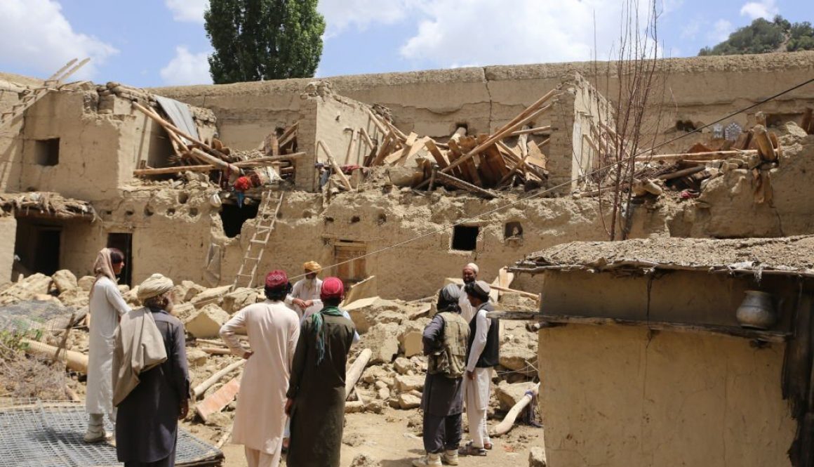 Orang-orang Afghanistan berdiri di dekat puing-puing sebuah bangunan setelah gempa berkekuatan 6,1 SR mengguncang provinsi perbatasan Paktika, Afghanistan pada 22 Juni 2022. (Foto oleh Bilal Guler/Anadolu Agency via Getty Images)