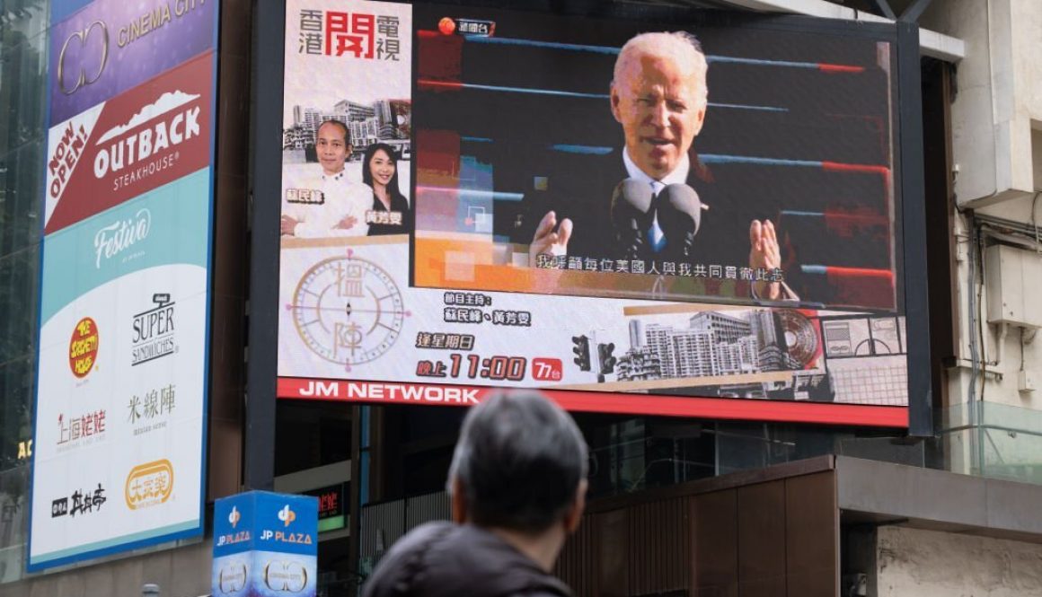 Seorang pria terlihat menonton laporan berita Presiden Joe Biden di layar lebar. (Foto oleh Isaac Wong/SOPA Images/LightRocket via Getty Images)