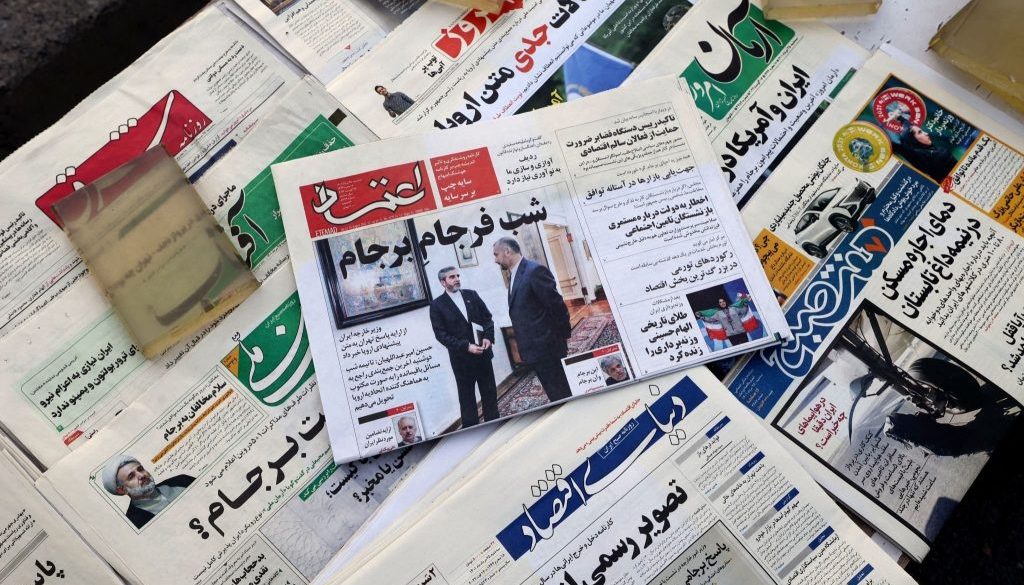 Sebuah gambar menunjukkan kios surat kabar dengan pemandangan halaman depan surat kabar Etemad bertuliskan judul dalam bahasa Farsi "Malam akhir JCPOA" dengan menunjukan Menlu Iran dan wakilnya pada 16 Agustus 2022. (Foto oleh ATTA KENARE/AFP via Getty Images)
