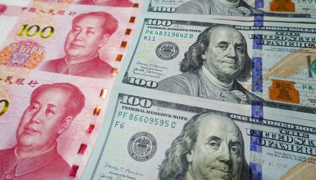 Dalam ilustrasi foto ini, uang kertas 100 dolar AS dan uang kertas 100 RMB terlihat ditampilkan. (Ilustrasi Foto oleh Sheldon Cooper/SOPA Images/LightRocket via Getty Images)