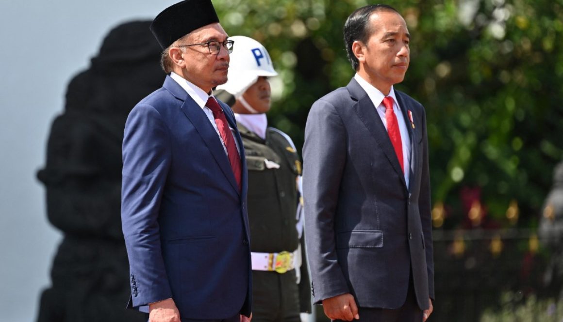 Malaysian Prime Minister Anwar Ibrahim (left) and President Joko “Jokowi“ Widodo attend a honour guard ceremony at the presidential palace in Bogor, West Java on January 9, 2023. (AFP/Adek Berry)