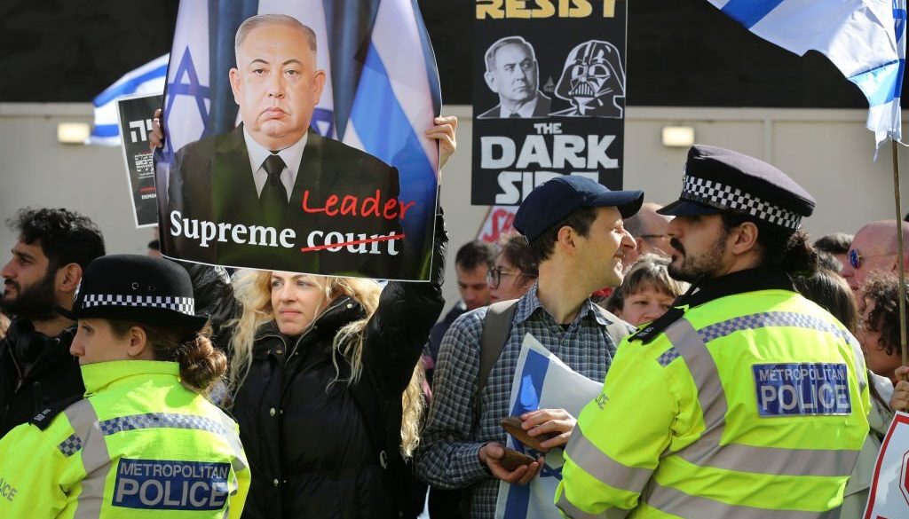 Seorang pengunjuk rasa memegang tanda yang membuat Netanyahu terlihat seperti seorang diktator China di Downing Street pada 24 Maret 2023 di London, Inggris. (Foto oleh Martin Pope/Getty Images)