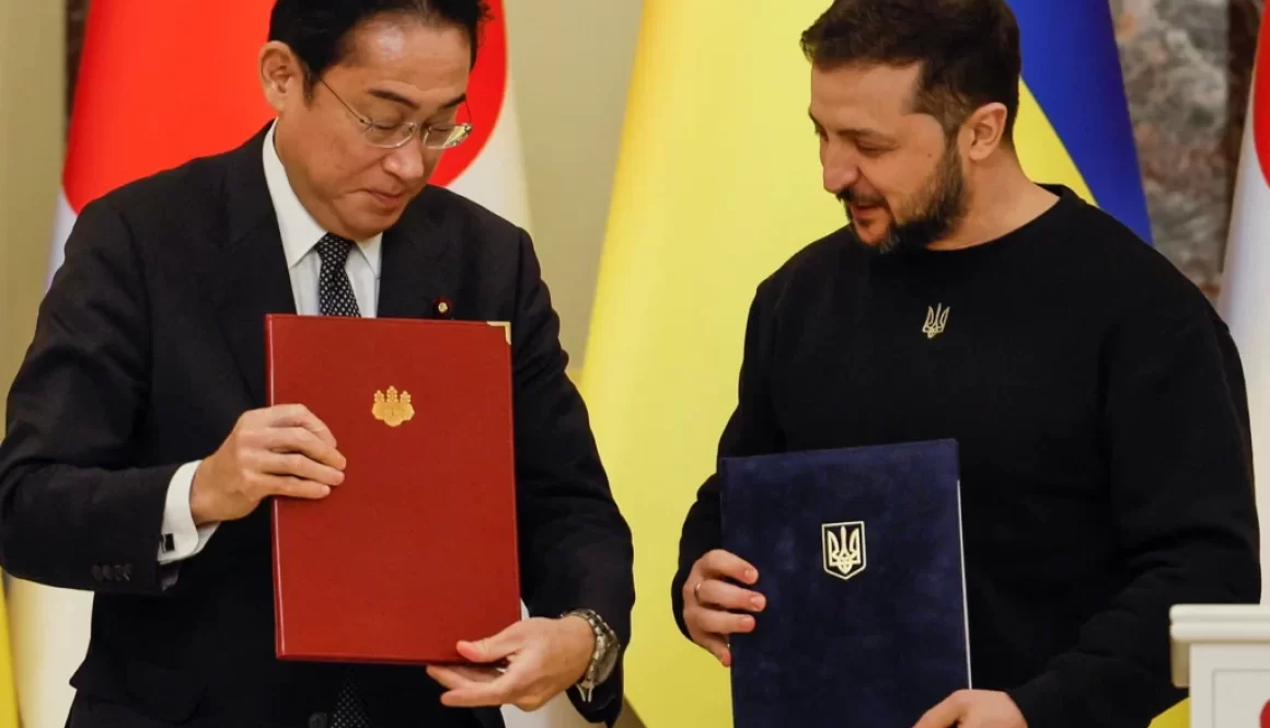 Ukraine's President Volodymyr Zelenskyy and Japanese Prime Minister Fumio Kishida hold documents as they attend a joint news conference in Kyiv [Alina Yarysh/Reuters]