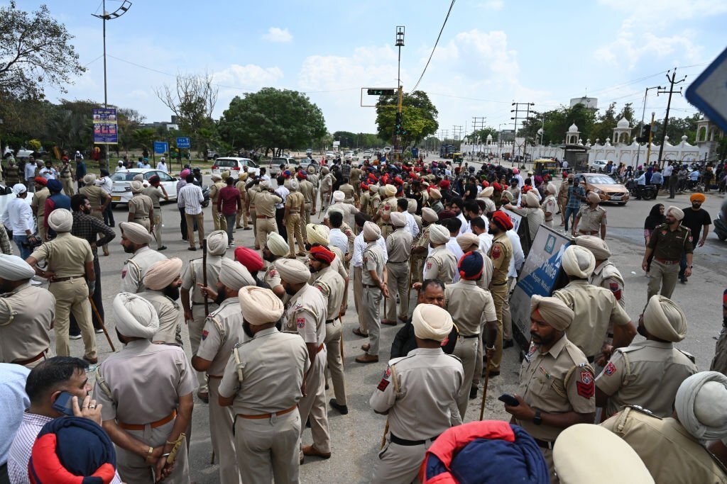 Polisi Punjab dengan paksa memindahkan para pendukung yang memprotes tindakan Polisi terhadap Amritpal Singh dari titik terang Jalan Bandara Internasional di Mohali, India. (Foto oleh Sanjeev Sharma/Hindustan Times via Getty Images)