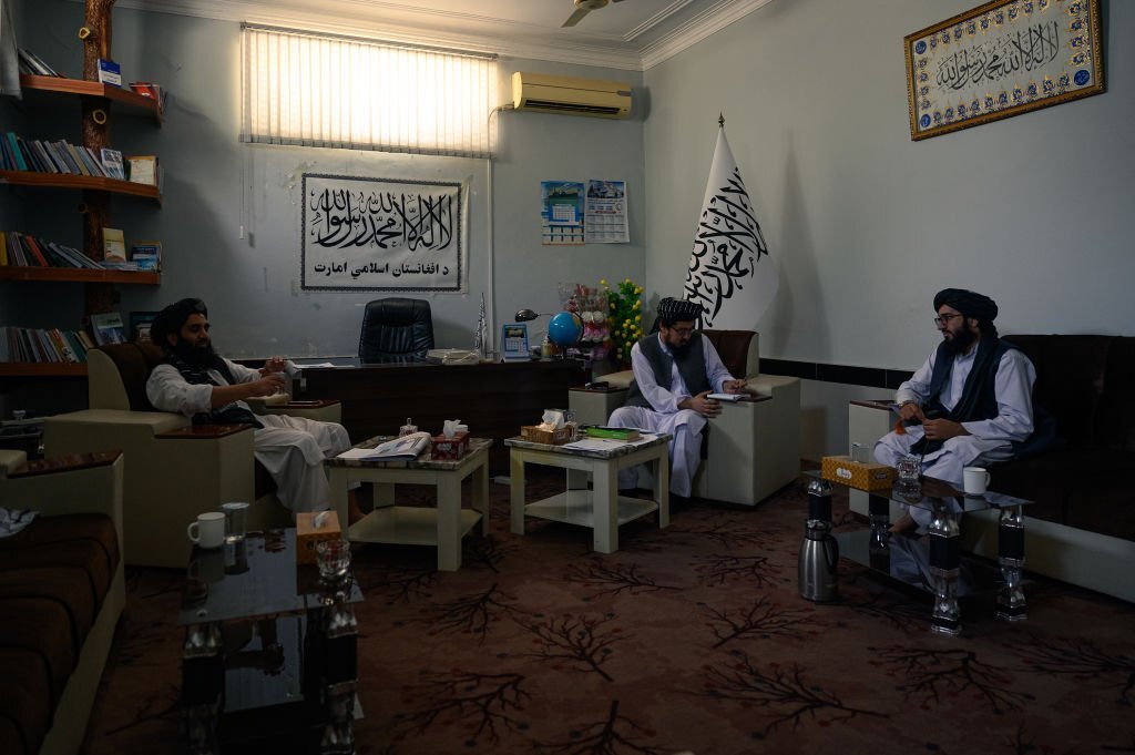 Inamullah Samangani, Wakil Juru Bicara Pusat (Tengah) Taliban duduk bersama pejabat Taliban lainnya di kantor barunya di departemen Kebudayaan dan Informasi kota Kandahar, di Afghanistan selatan, pada 25 Mei 2023 (Foto oleh Elise Blanchard untuk The Washington Post via Getty Images)