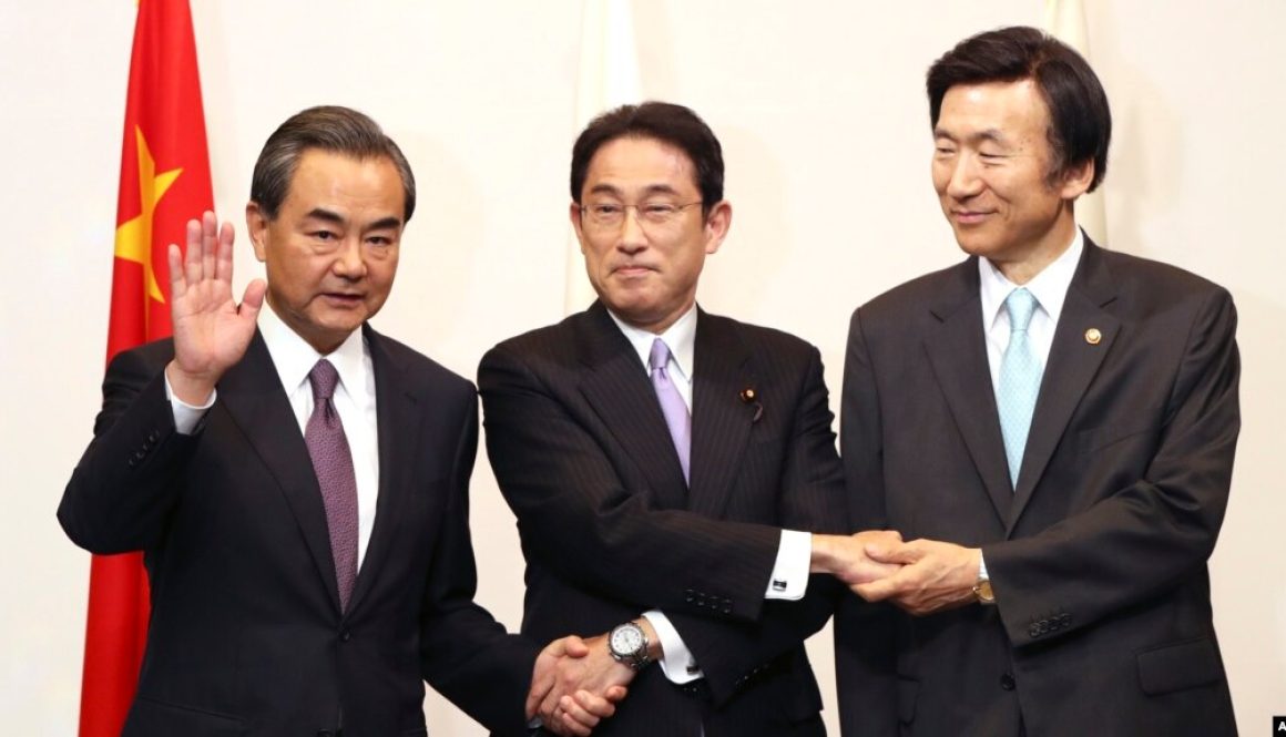 Japanese Foreign Minister Fumio Kishida, center, Chinese Foreign Minister Wang Yi, left, and South Korean Foreign Minister Yun Byung-se, right, pose for photographers prior to the official banquet of the trilateral foreign ministers meeting in Tokyo, Aug.