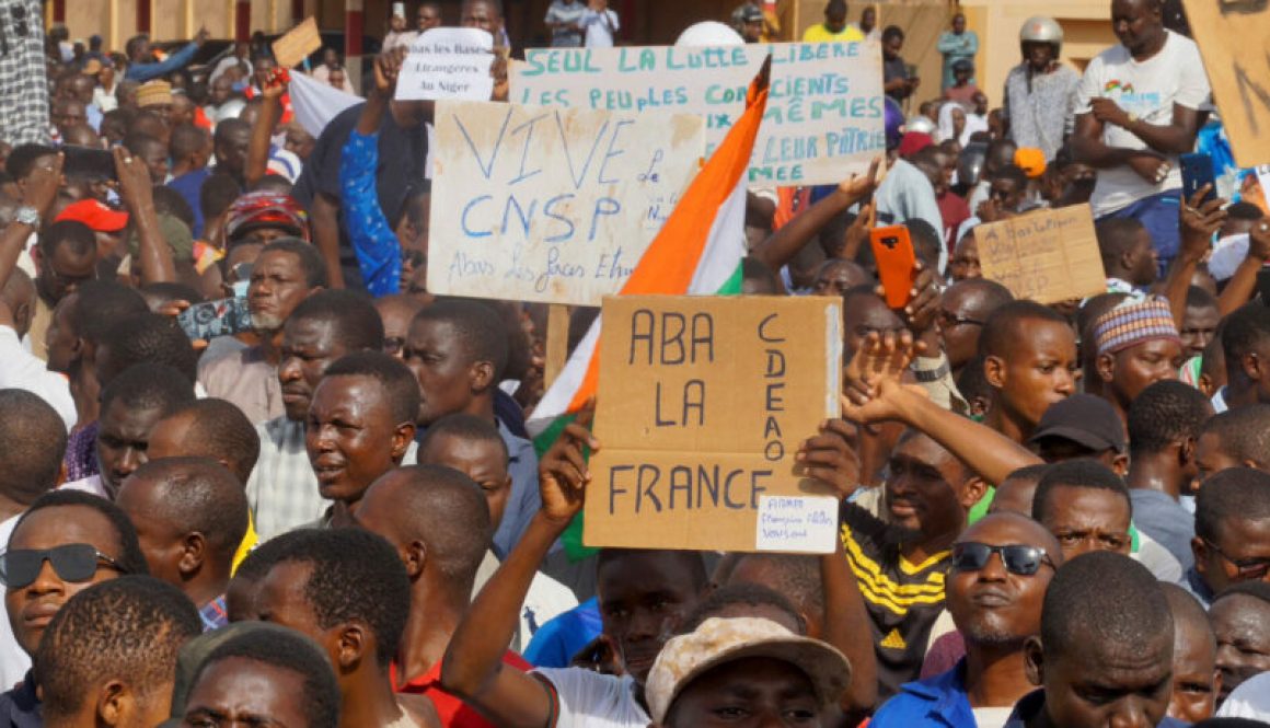 Protesters in Niger hold signs in support of the CNSP and against France