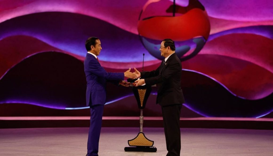 Presiden Indonesia Joko Widodo (kiri) menyerahkan palu ASEAN kepada Perdana Menteri Laos Sonexay Siphandone saat upacara penutupan KTT ASEAN ke-43 di Jakarta pada 7 September 2023. (Foto oleh WILLY KURNIAWAN/POOL/AFP via Getty Images)