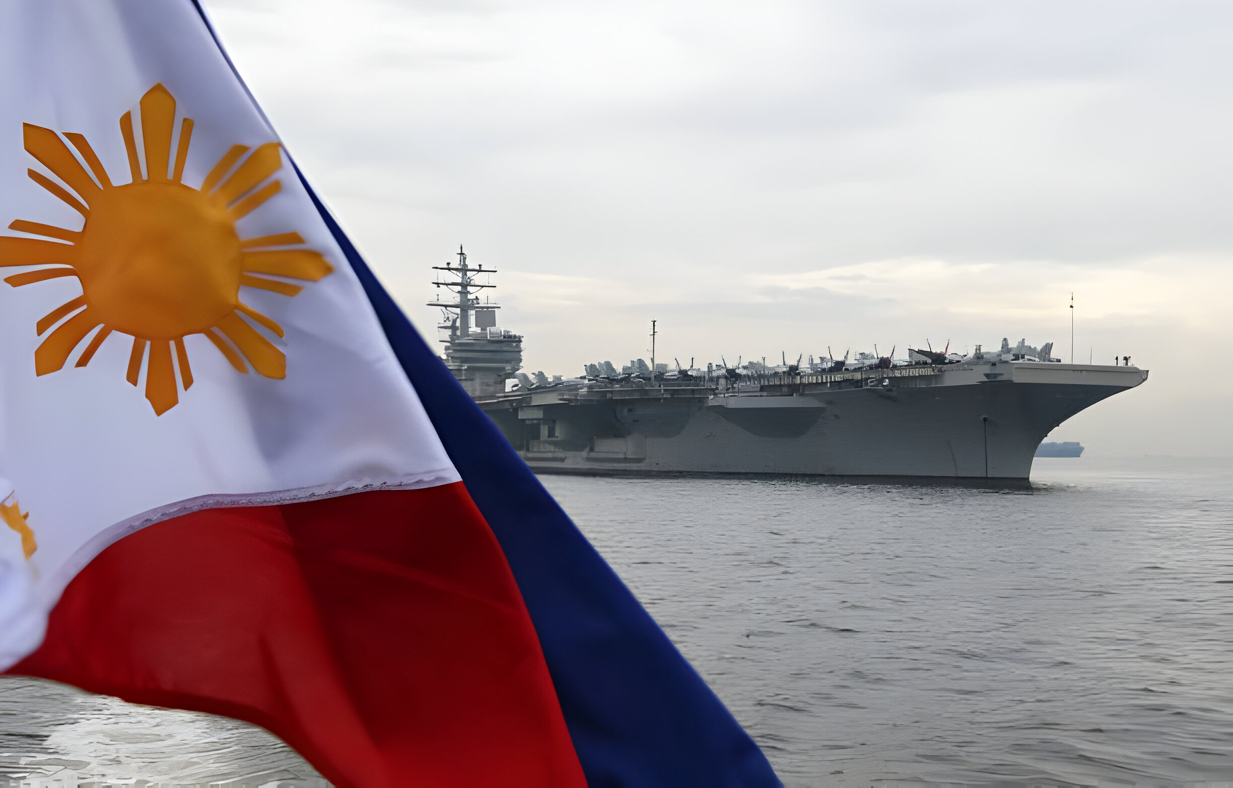 A Philippine flag flutters as the nuclear-powered aircraft carrier USS Ronald Reagan (CVN-76) is seen anchored off Manila bay on June 26, 2018. - A US aircraft carrier visited the Philippines on June 26, the third such call in four months, as its admiral hailed America's "enduring presence" in a region where China's military build-up had raised tensions. (Photo by TED ALJIBE / AFP) (Photo by TED ALJIBE/AFP via Getty Images)