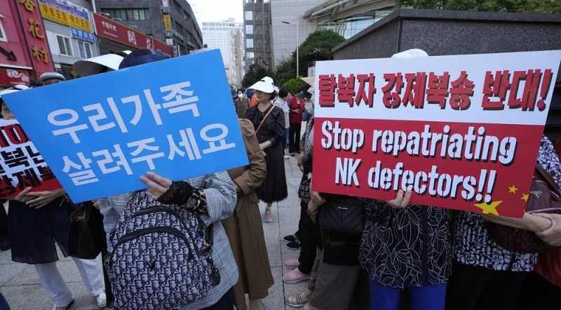 Para pembelot Korea Utara memegang spanduk saat unjuk rasa menuntut pemerintah Tiongkok untuk melepaskan pembelot Korea Utara yang ditangkap di Tiongkok di dekat Kedutaan Besar Tiongkok di Seoul, Korea Selatan.