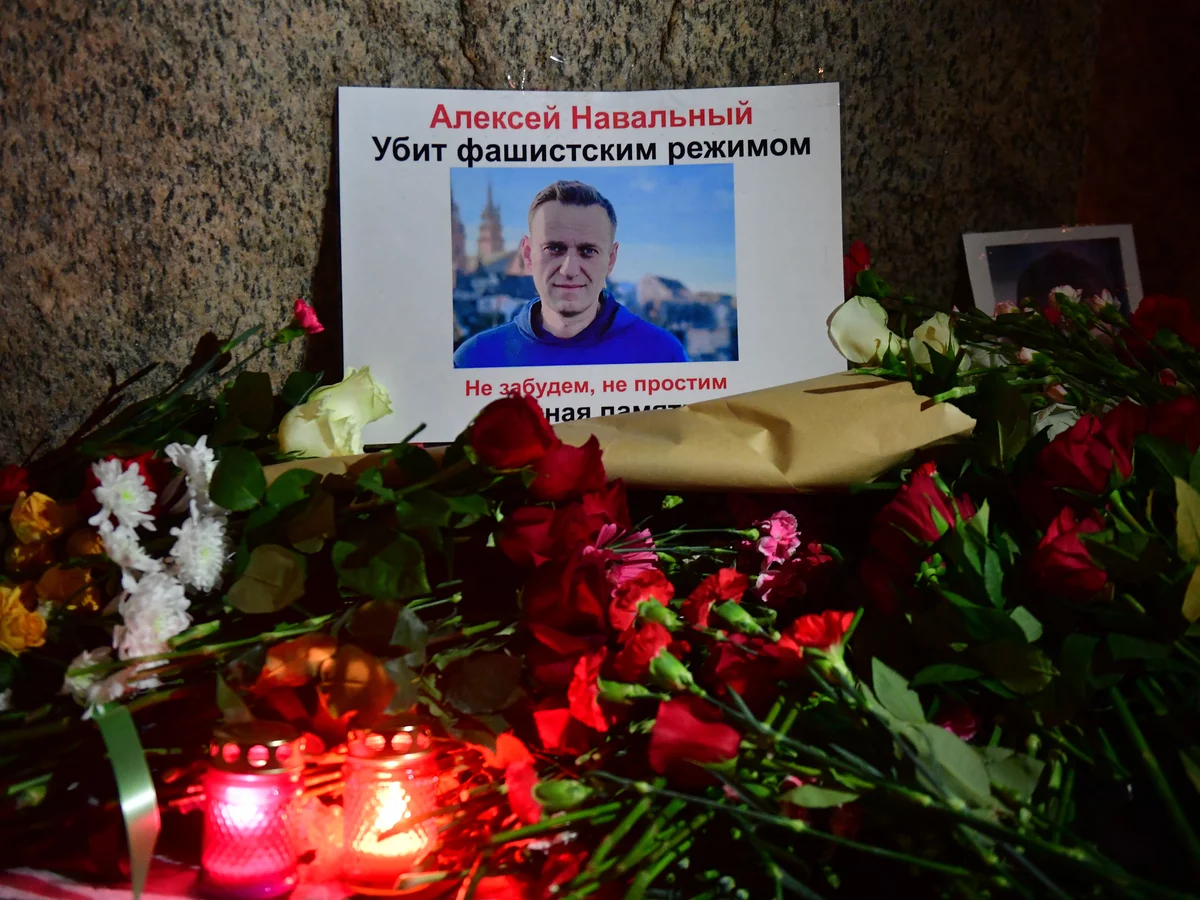 Flowers lay next to a picture of late Russian opposition leader Alexei Navalny at a makeshift memorial organized at the monument to the victims of political repressions in Saint Petersburg. OLGA MALTSEVA/AFP via Getty Images