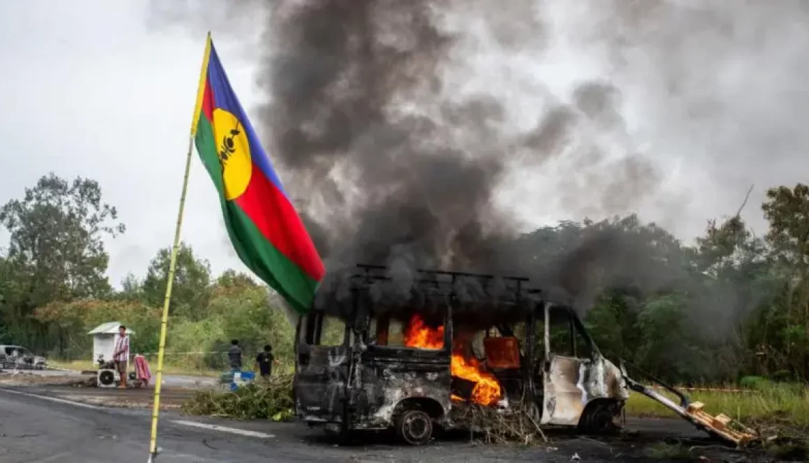 Bendera Kanak berkibar di seberang kendaraan yang terbakar di sebuah ruas jalan di La Tamoa, Kaledonia Baru, 19 Mei 2024.