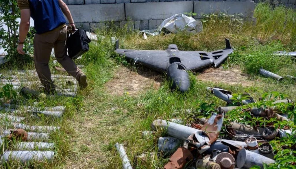 A war crimes prosecutor stands next to the wreckage of a Russian Shahed-136 drone, developed by Iran and known as Geran-2 in Russia, in Kharkiv on July 30