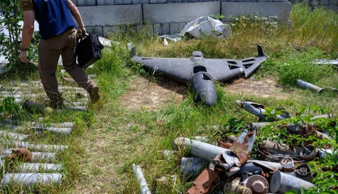 A war crimes prosecutor stands next to the wreckage of a Russian Shahed-136 drone, developed by Iran and known as Geran-2 in Russia, in Kharkiv on July 30